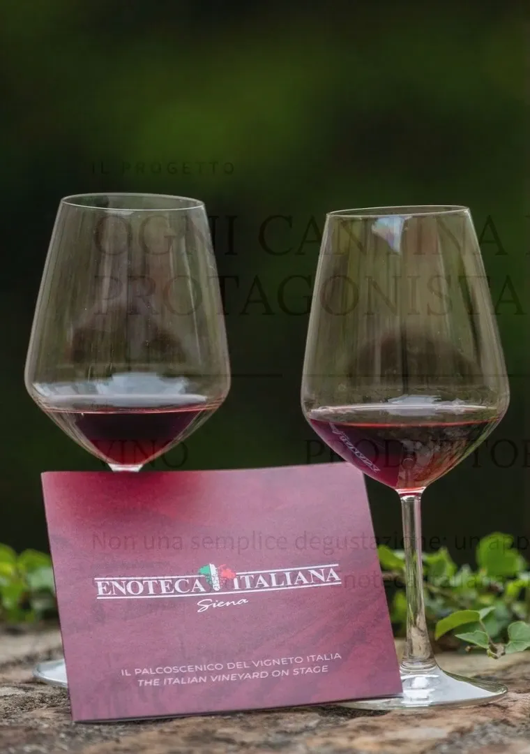 Due calici di vino rosso e la cartolina di Enoteca Italiana Siena